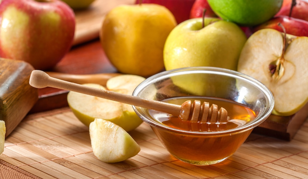 Apfeldicksaft in einer Schale mit Äpfeln im Hintergrund
