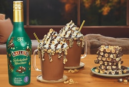Baileys Schokolade Haselnuss Flasche, daneben zwei Tassen mit Sahne.png