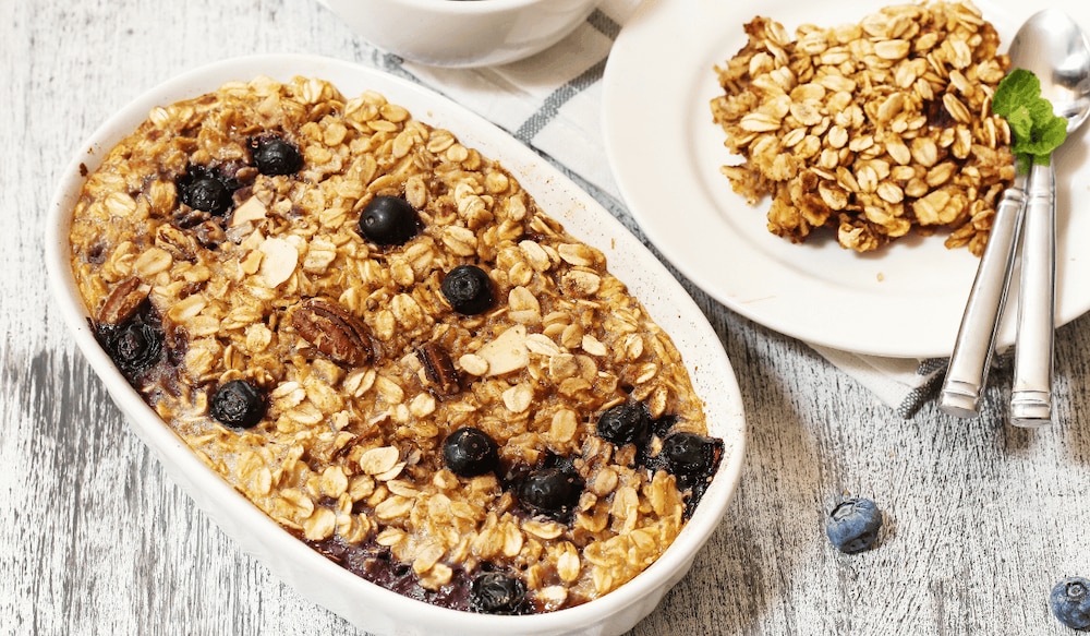 Baked Oatmeal in einer Auflaufform mit Beeren und Nüssen