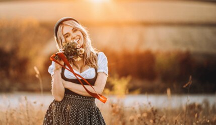 Frau mit blonden Haaren im Dirndl auf einem Feld