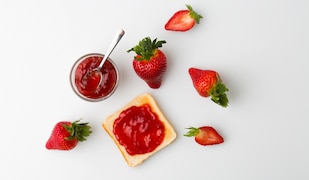 Erdbeermarmelade in einem Einmachglas mit frischen Erdbeeren daneben