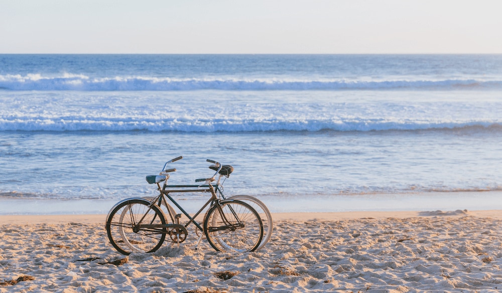 Fahrräder stehen vor dem Meer am Strand