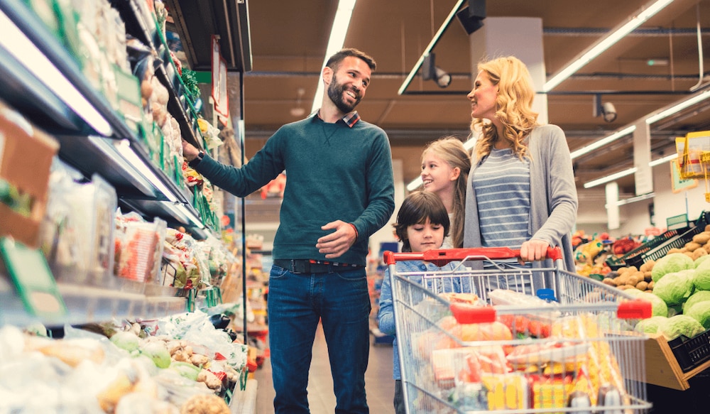 Familie beim Einkaufen im Discounter am Kühlregal