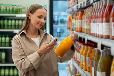 Frau kauft Saft in einem Supermarkt