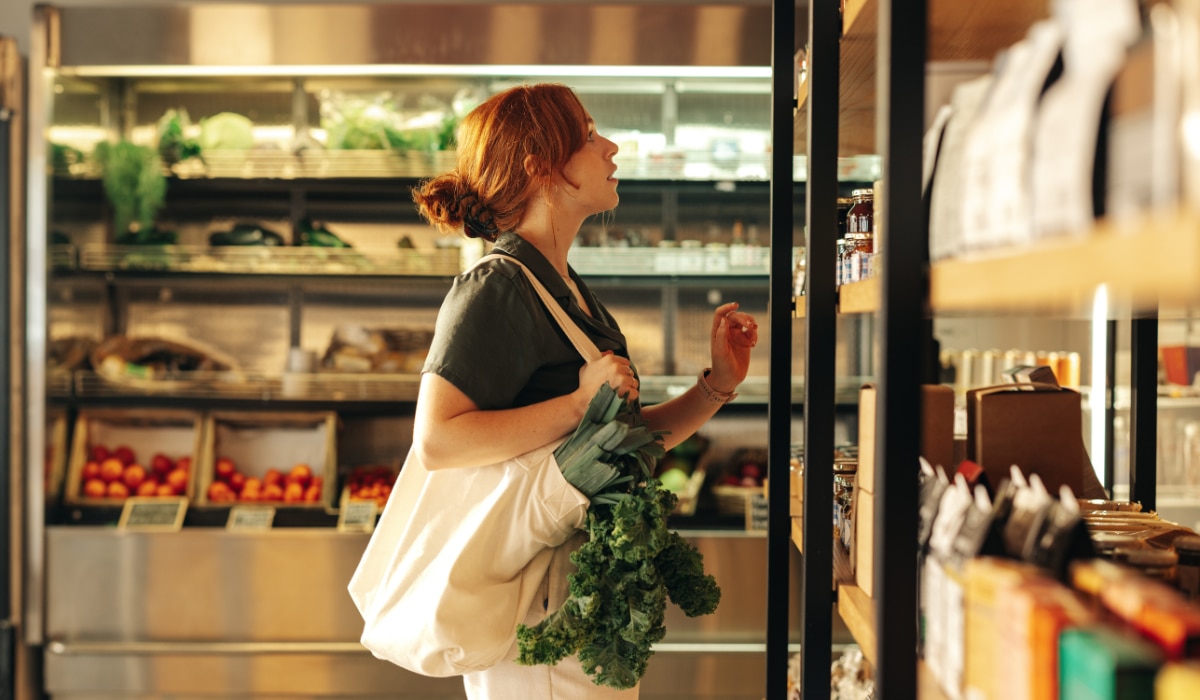 Frau kauft in einem Supermarkt vegetarische Produkte ein