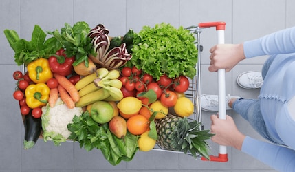 Frau mit einem Einkaufswagen voller veganer Produkte