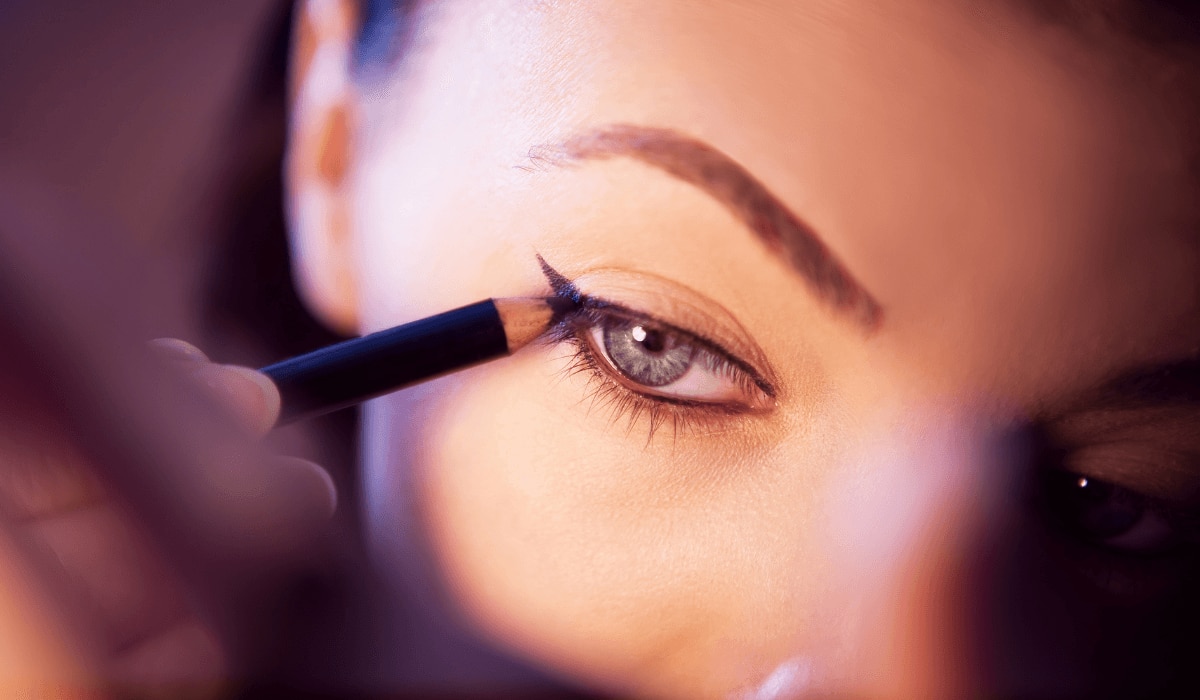 Frau schminkt sich mit Eyeliner