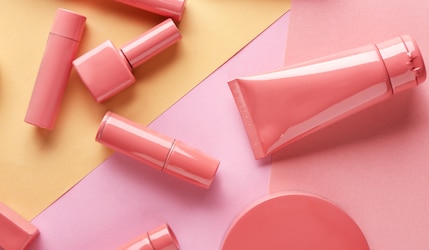 rosa Kosmetik auf rosa/orange Hintergrund