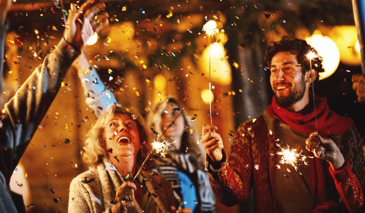 Gruppe von Menschen an Silvester mit Wunderkerzen