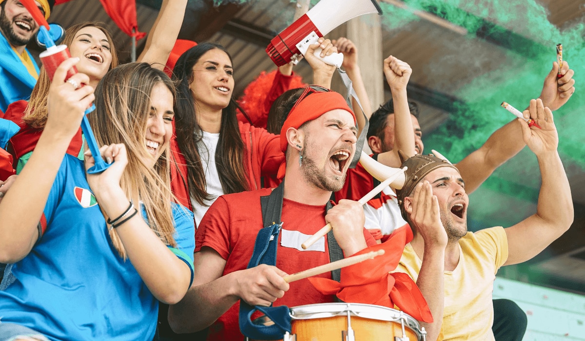 Gruppe von Menschen feiert in verschiedenen Nationaltrikots