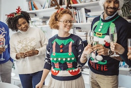 Gruppe von Menschen in verschiedenen Weihnachtspullovern zu Weihnachten 2024