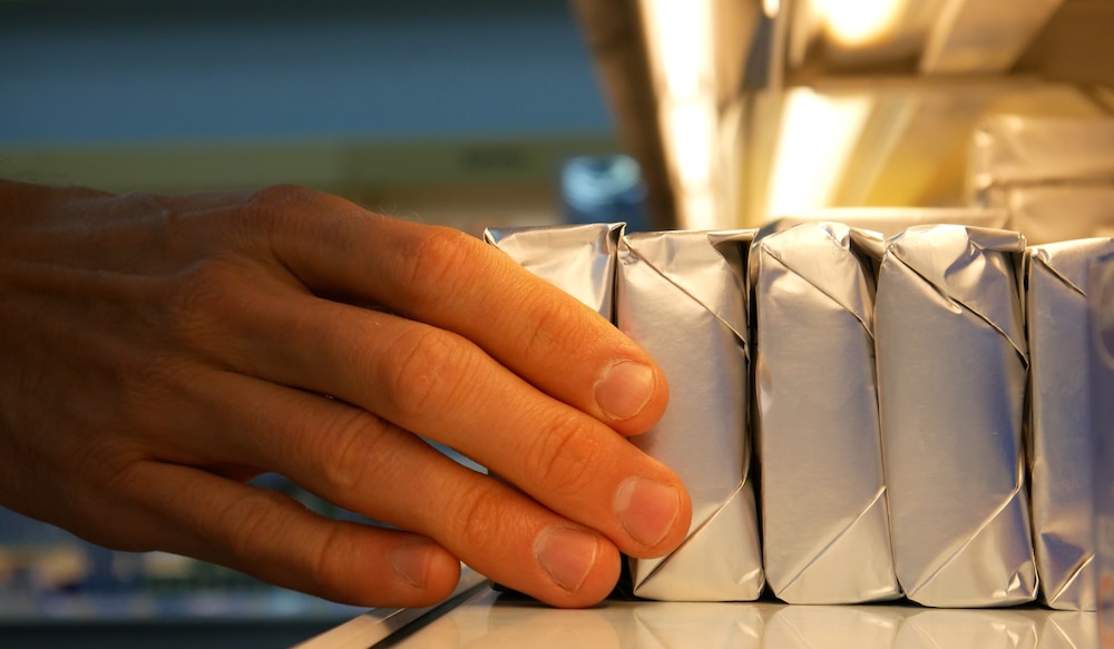 Hand greift nach Packungen Butter
