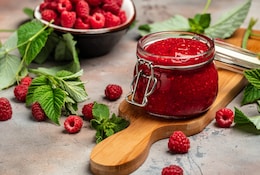Himbeer Marmelade in einem Einmachglas mit frischen Himbeeren