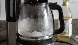 Verkalkte, alte Kaffeemaschine, die auf einer Küchenzeile steht