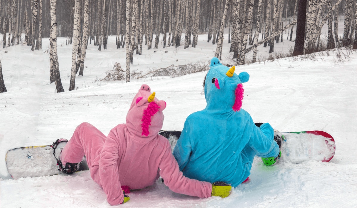 Kigurumi Ski-Onesie im Schnee mit Snowboard