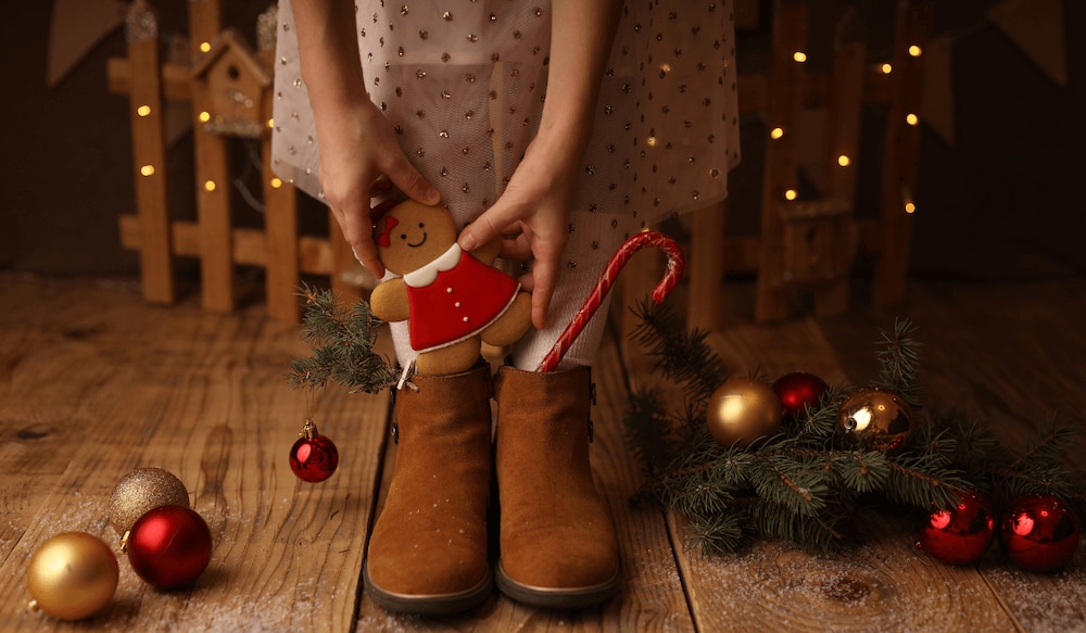 Kind bekommt Geschenke vom Nikolaus in einem Nikolausstiefel