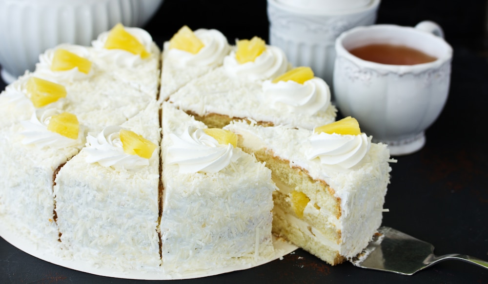 Kokos Ananas Torte mit Tasse Tee im Hintergrund.png