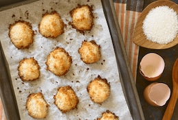 Frisch gebackene Kokosmakronen auf einem mit Backpapier belegtem Blech