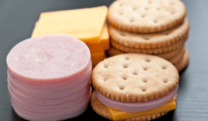 Käse, Schinken und Cracker auf grauem Tisch