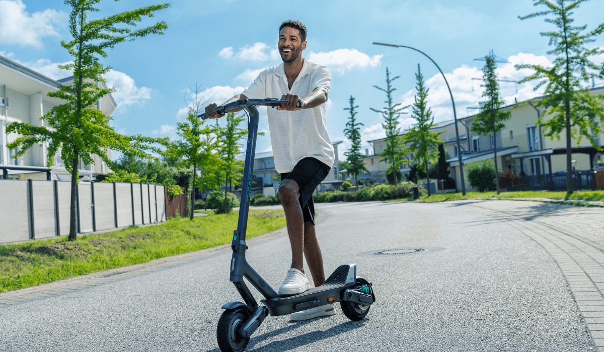 Mann fährt auf einem EGRET E-Scooter.png