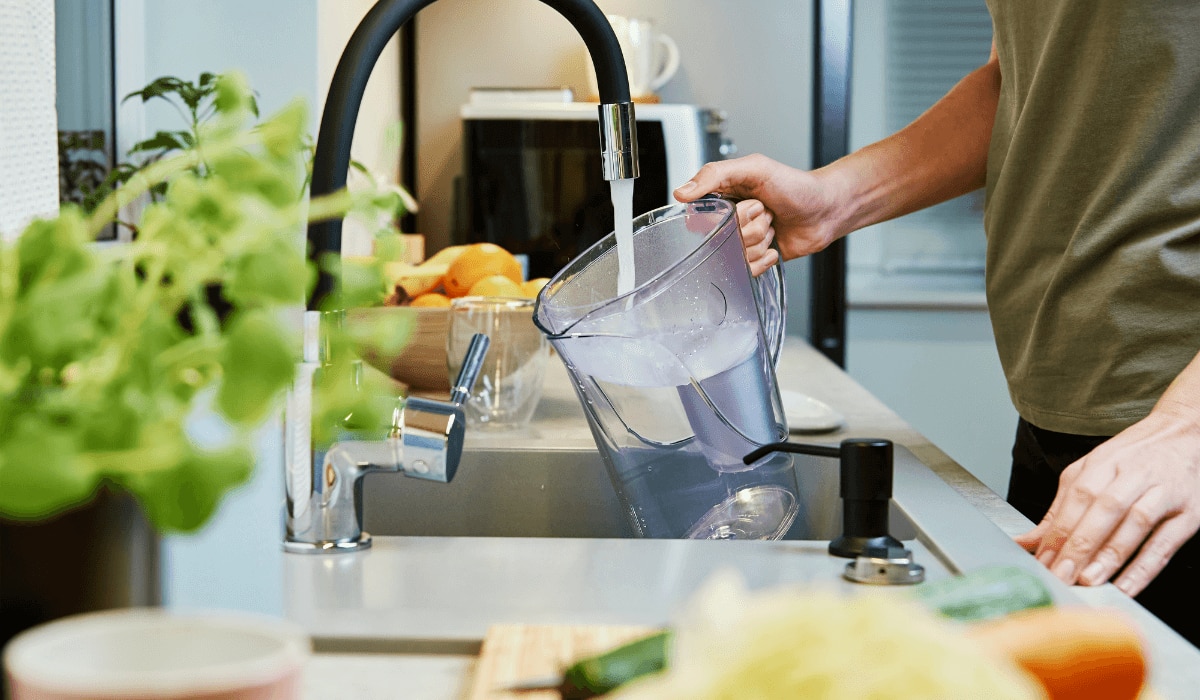 Mann füllt eine BRITA Wasserkanne mit Wasser.png