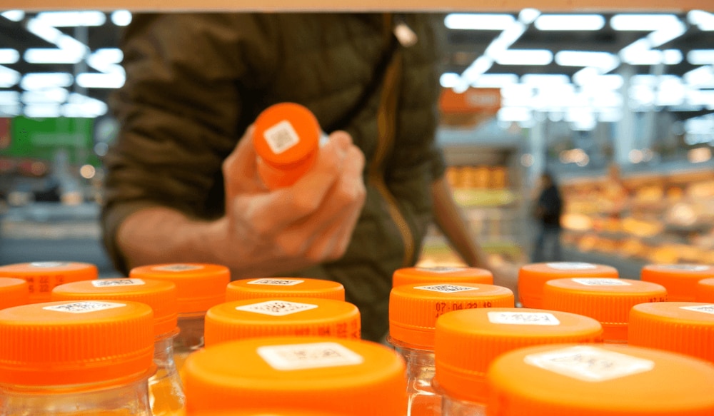 Mann greift in einem Supermarkt nach Orangensaft