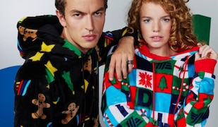 Mann im schwarzen Pullover links, Frau im blau,rot, grünem Pullover rechts