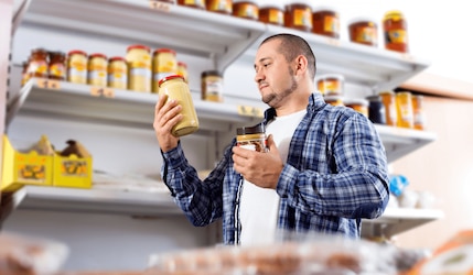 Mann kauf in einem Supermarkt Erdnussbutterpulver