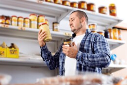Mann kauf in einem Supermarkt Erdnussbutterpulver