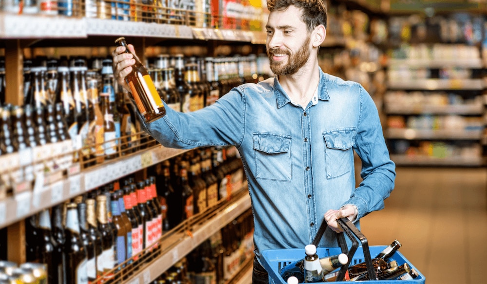 Mann kauft Bier in einem Supermarkt