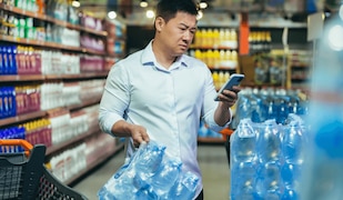 Mann kauft in einem Supermarkt destilliertes Wasser