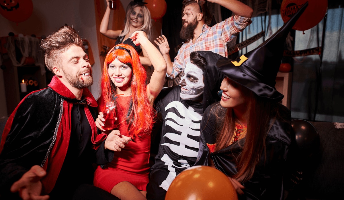 Damen und Herren in Halloween-Kostümen auf einer Party