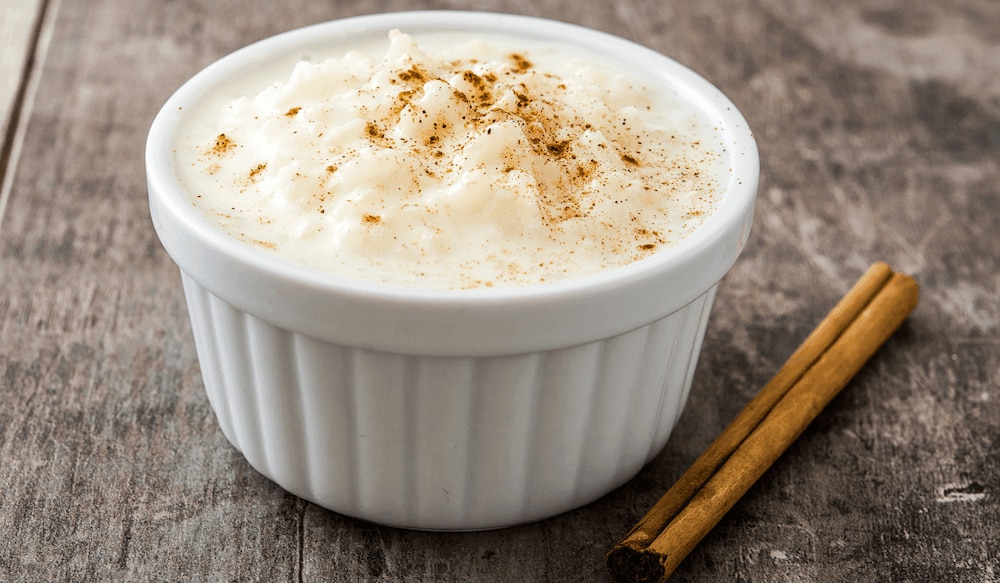 Milchrreis mit Zimt in einer Schale mit Zimtstange