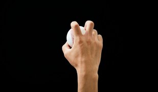 schwarzer Hintergrund, Hand hält einen Ball