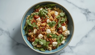 Nudelsalat mit getrockneten Tomaten, Mozzarella und Rucola
