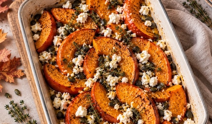 Ofenkürbis mit Feta in einer weißen Aufflaufform