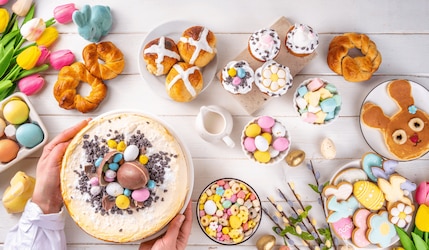Gedeckter Tisch mit Brötchen, Tulpen, bunten Eiern und Co. für einen Osterbrunch