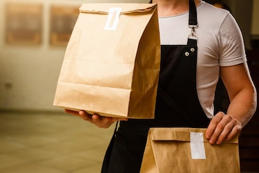 Person hält zwei Papiertüten