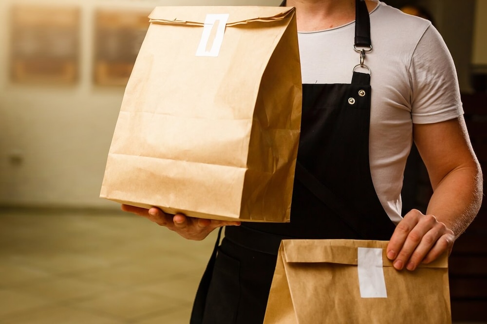 Person hält zwei Papiertüten