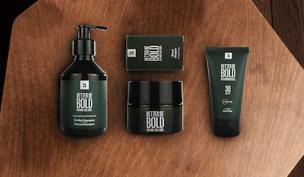 Produkte von Better be Bold in der Verpackung vor Holz Hintergrund