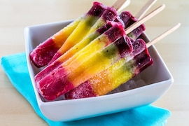 Regenbogen-Eis am Stiel in Schale liegend