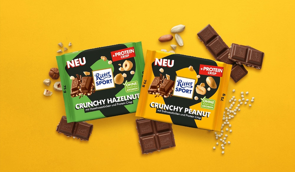 zwei neue Sorten Ritter Sport Proteinschokolade auf gelbem Hintergrund