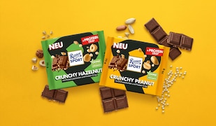 zwei neue Sorten Ritter Sport Proteinschokolade auf gelbem Hintergrund