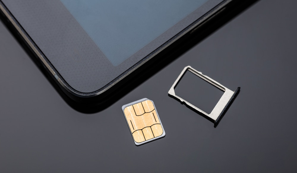 SIM Karte liegt neben einem Smartphone