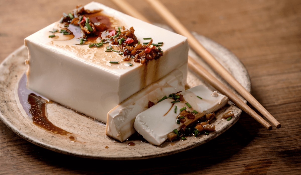 Seidentofu mit Sojasauce und Essstäbchen auf einem Teller angerichtet