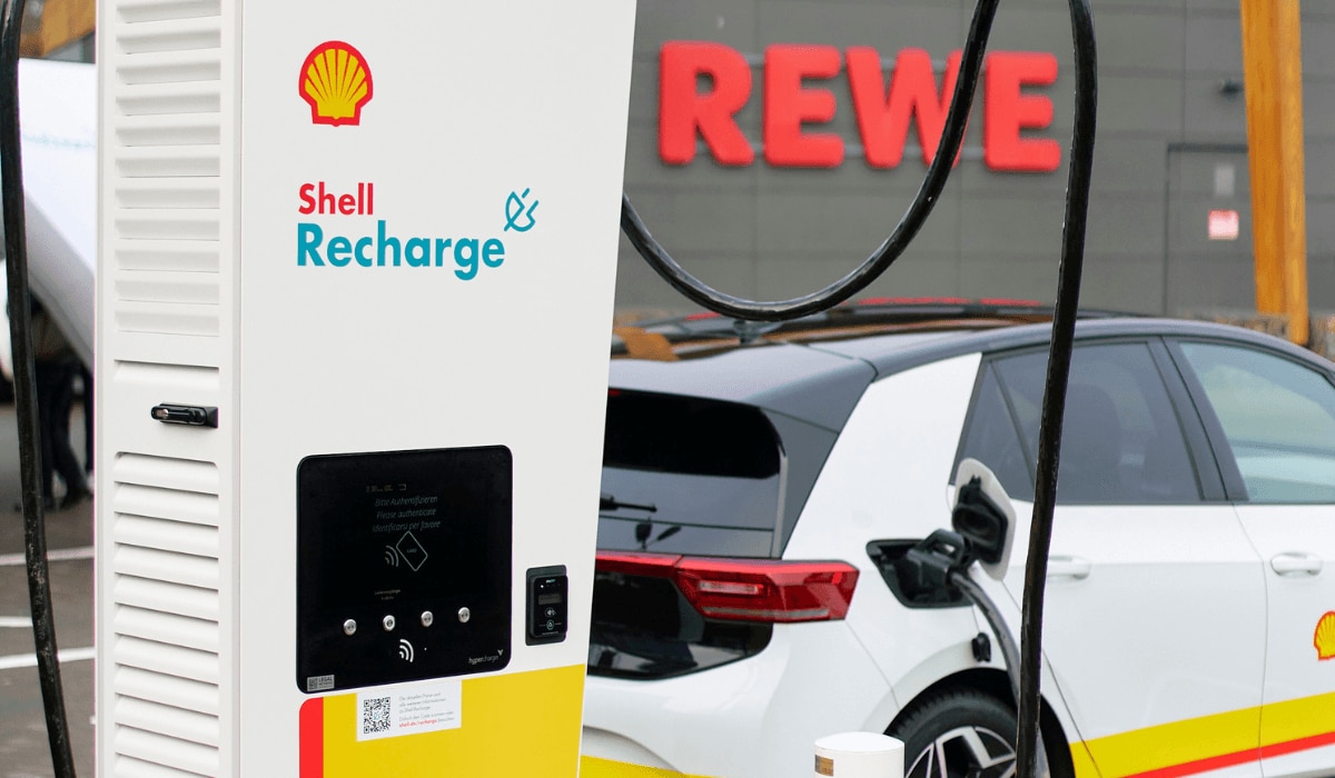 Shell E-Ladestation an einer REWE Filiale mit E-Auto verbunden.png