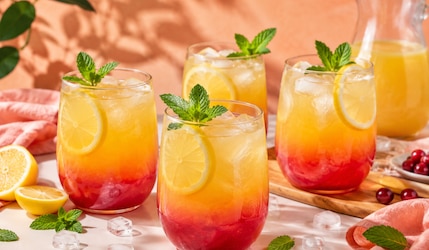 Sunset Lemonade in 4 ovalen Gläsern mit Minze schön angerichtet