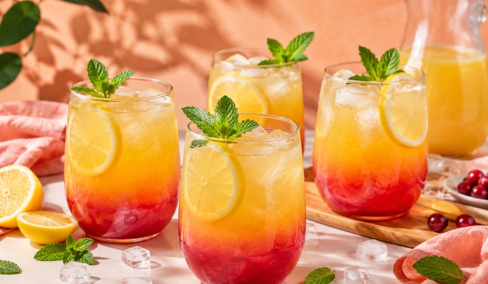 Sunset Lemonade in 4 ovalen Gläsern mit Minze schön angerichtet