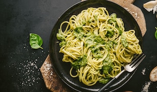 Teller mit Nudeln und Pesto und einer Gabel