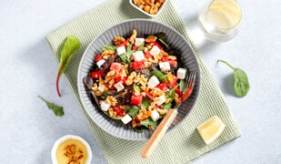 Wassermelonen-Feta-Salat mit Rucola und Walnüssen auf einem Teller angerichtet